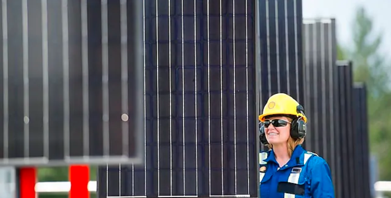 A Shell employee inspects the solar panels at a well site in the Groundbirch field. Photograph courtesy Shell Canada