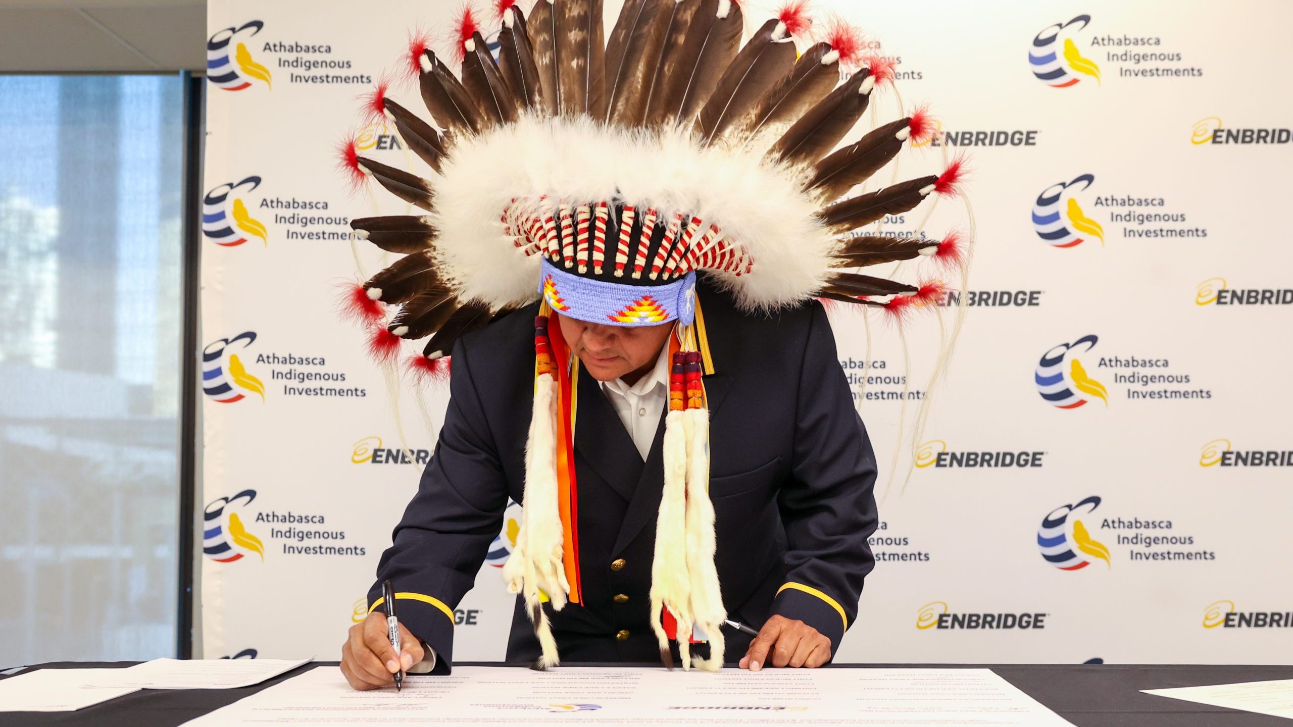 Chief Greg Desjarlais of Frog Lake First Nation signs a historic agreement 
between Enbridge and 23 First Nation and Métis communities in September 2022. The communities acquired, collectively, an 11.57% non-operating interest in seven Enbridge-operated pipelines in the Athabasca region of northern Alberta for $1.12 billion on September 22, 2022.
Photo courtesy Enbridge