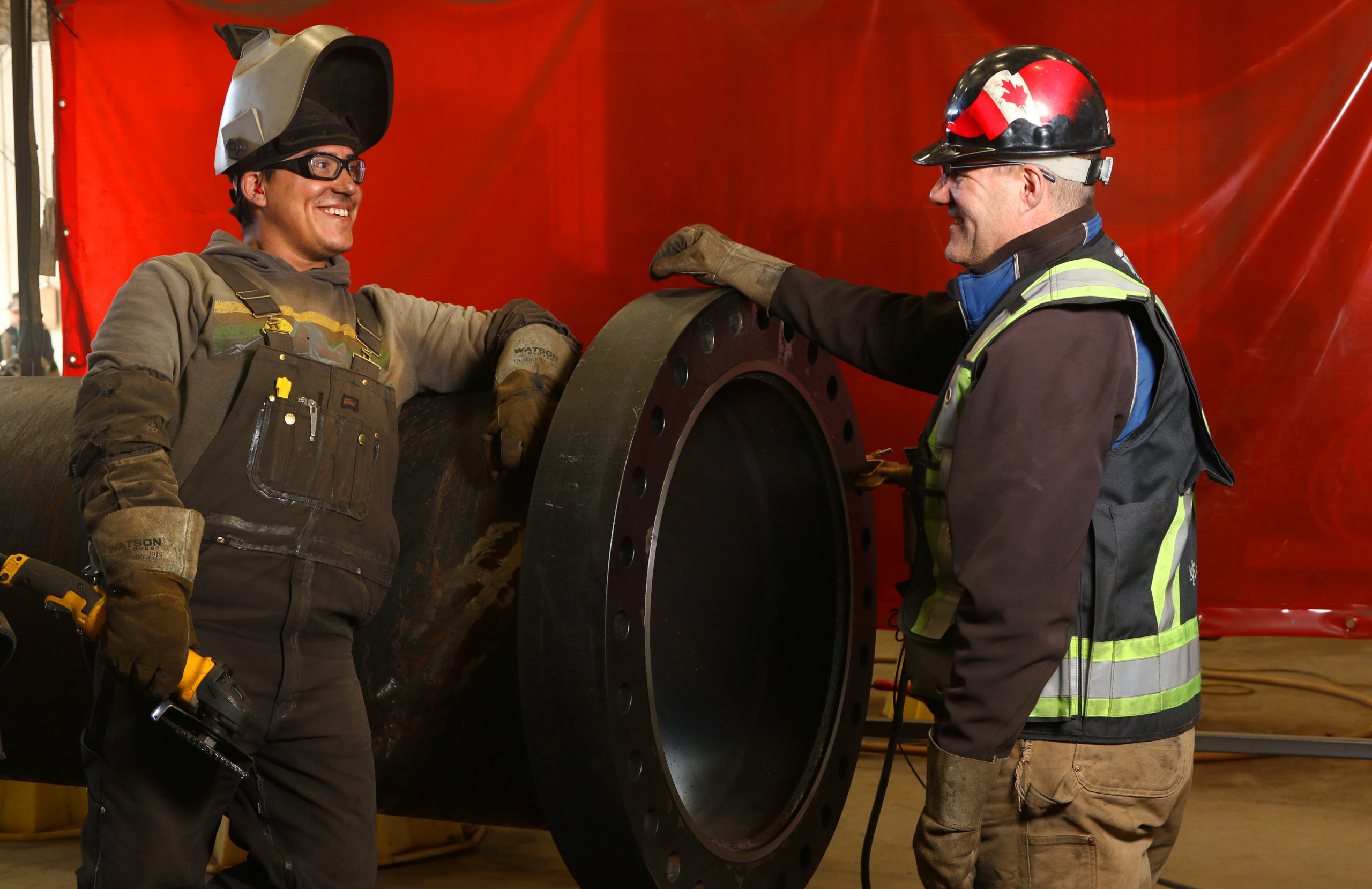 Pressure welder Donovan Doll (left) talks with Jon Rivard, CEO of CMR Fabricators Inc., at the company's facility in Penhold, Alberta. Photograph for Canadian Energy Centre