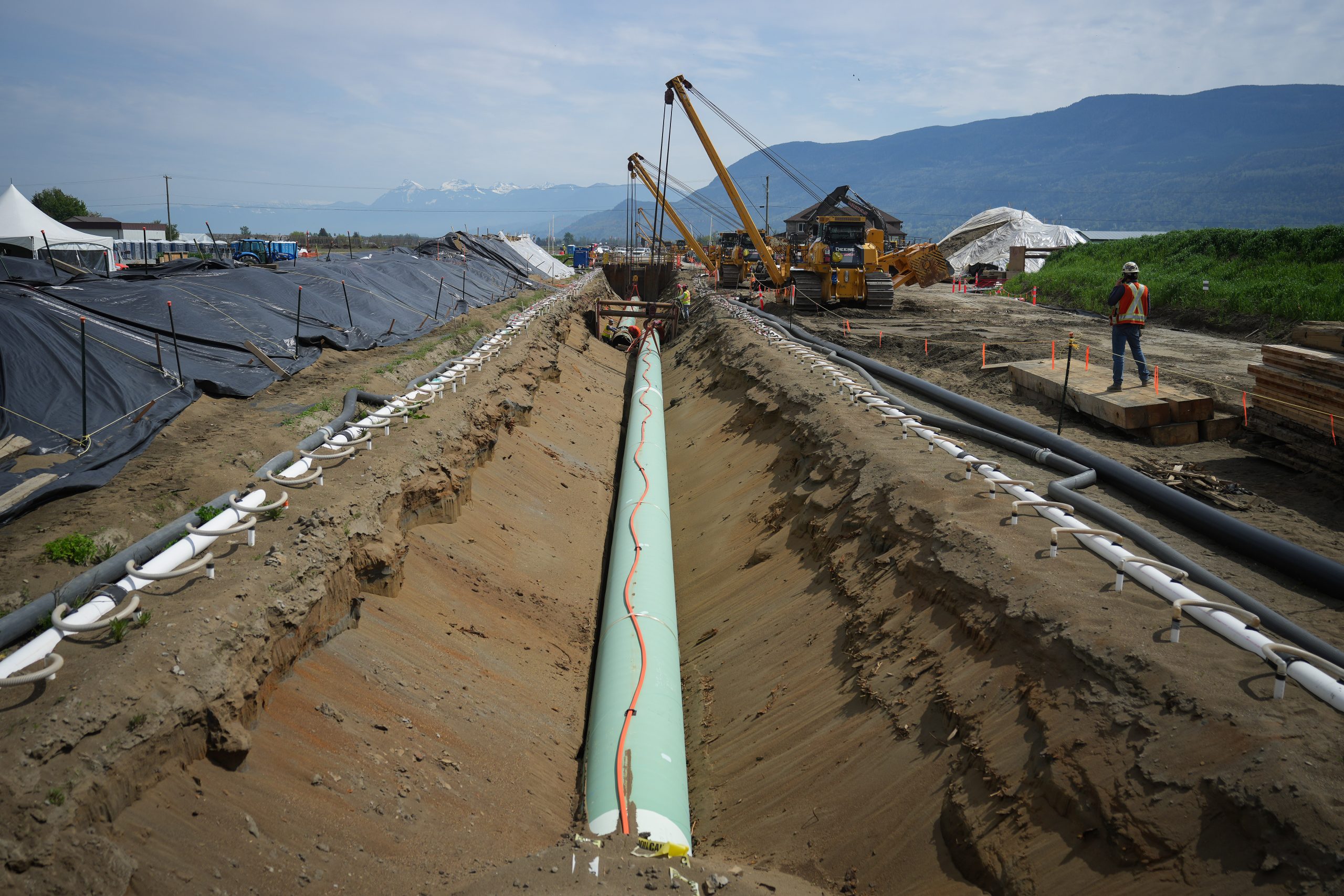 Workers lay pipe during construction of the Trans Mountain pipeline expansion on farmland in Abbotsford, B.C. on Wednesday, May 3, 2023. CP Images photo