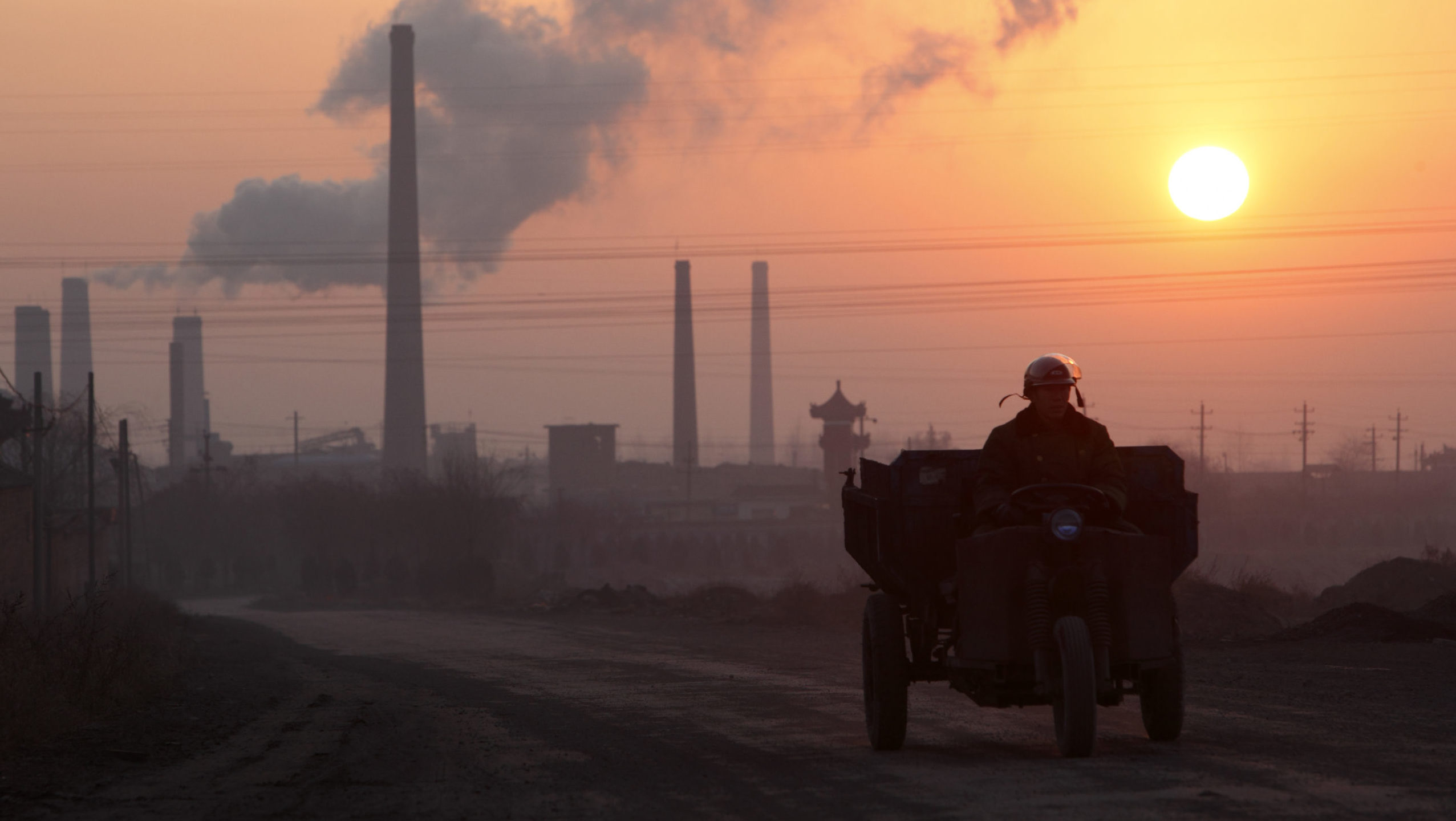 A man drives his tractor past a coal coking factory at sunrise in Linfen, Shanxi Province, China. Getty Images photo
