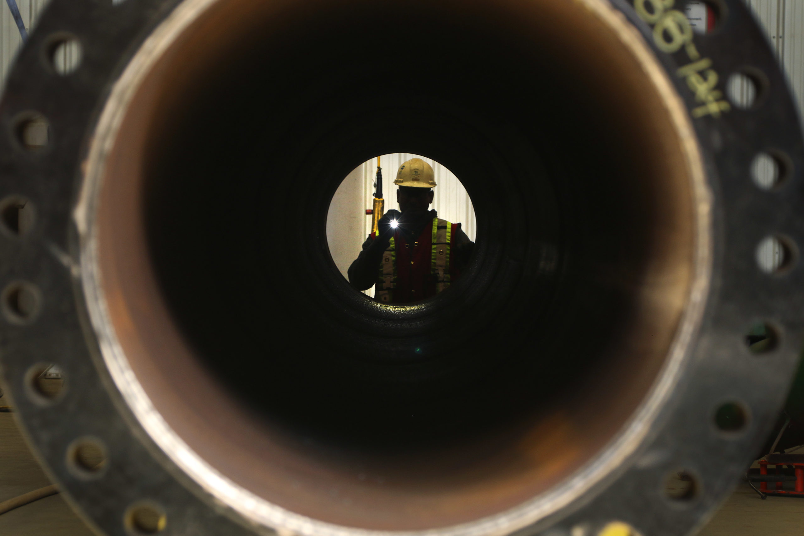 Quality control inspector Ram Lakshmanan checks pipe at CMR Fabricators' facility in Penhold, Alberta. Photograph for Canadian Energy Centre